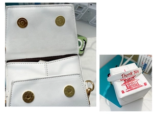 Detail showing white PU crossbody bag interior with dual gold magnetic closures and stitching