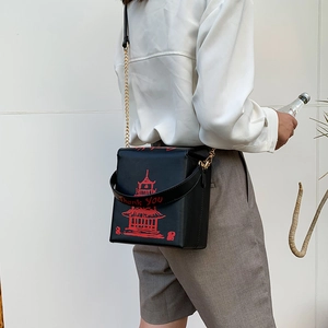 Detail of square black PU crossbody bag with red pagoda print and gold chain strap