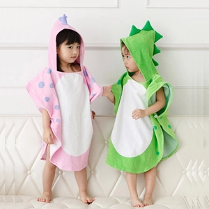 Kids hooded cotton dinosaur bathrobes in pink and green colors on soft white sofa