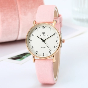 Close-up of a pink matte leather strap and rose gold quartz watch on velvet