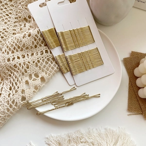 Gold wavy bobby pins for hair styling shown with white display card packaging