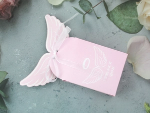 Detailed view of pink angel wing gift box with white ribbon and Thank You text