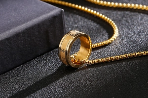 Detailansicht des goldenen Mantra-Drehrings als Anhänger an einer passenden Kette
