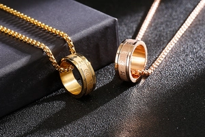 Detailansicht der drehbaren Edelstahlringe in Gold und Roségold mit gravierten Symbolen