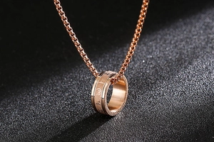 Detail eines drehbaren Rings in Roségold mit Symbolen an einer Box-Halskette