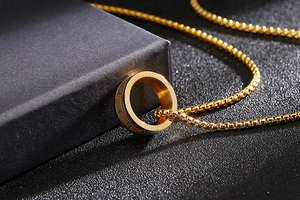 Detail eines drehbaren Edelstahlrings mit Sanskrit-Mantra auf gold-silbernem Band