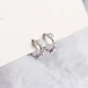 Macro shot of silver micro-pave cubic zirconia hoop earrings on a minimalist white card