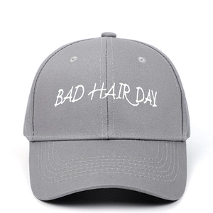 Détail de casquette grise avec broderie blanche BAD HAIR DAY et texture en coton sergé