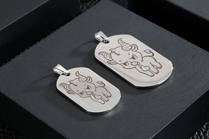 Macro view of polished stainless steel military tags with engraved zodiac ox design