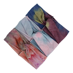 Detailed view of bohemian tie-dye elastic headbands with a central twist knot design