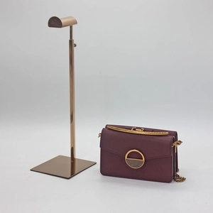 Detail of rose gold metal handbag stand with adjustable height and stable square base