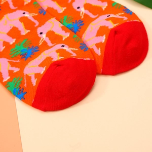 Detail shot of cotton blend socks with orange base and pink elephant pattern