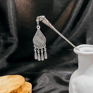 Detail of silver vintage hairpin featuring turquoise hollow flower and elegant tassels