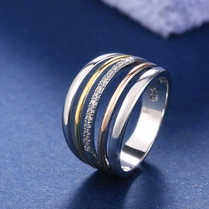 Detailed macro of a triple-tone S925 sterling silver multi-layer ring with pavé zircons