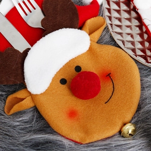 Christmas reindeer cutlery holder with red nose and bell on grey textured tabletop decor