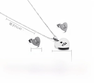Macro view of stainless steel heart jewelry set with Mãe engraving and crown detail