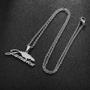 Macro shot of silver Jamaica map pendant necklace with cursive lettering on black texture