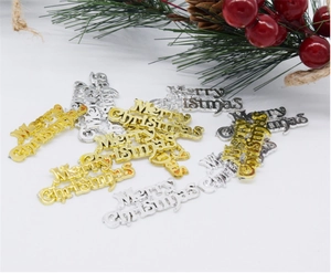Detail of gold and silver Merry Christmas metal charms with festive red berries decor