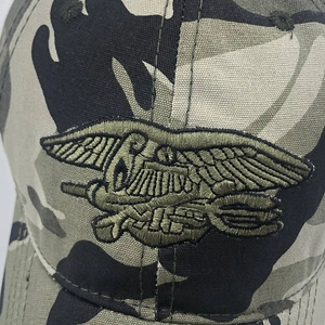 Detailed embroidery of US Navy SEALs trident logo on a camouflage tactical baseball cap