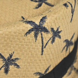 Detailed macro view of woven straw texture with blue palm tree print and black ribbon