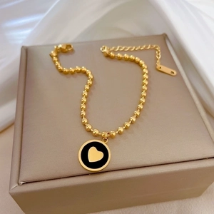 Bracelet élégant pour femme en acier titane doré avec pendentif coeur noir et billes