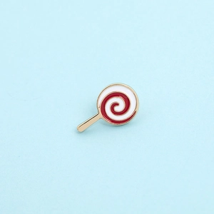 Macro detail of lollipop enamel brooch with red white spiral pattern and gold stem