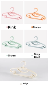 Detail of colorful plastic kids hangers featuring central bow and non-slip shoulder grooves