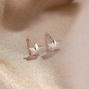 925 silver star earrings with iridescent crystal facets on champagne satin background