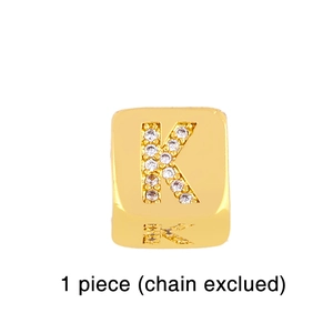 Detailed view of a gold cubic zirconia letter K charm for DIY jewelry bracelets