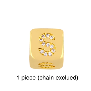 Detailed macro view of a gold-plated dice-shaped alphabet S charm with sparkling cubic zirconia