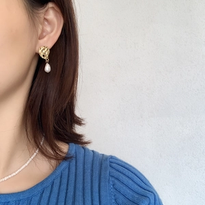 Close-up of Baroque pearl earrings and matching necklace worn by a model for a vintage look