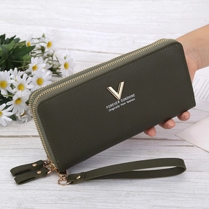 Close-up of a green double-zipper wallet featuring lychee texture and golden V hardware