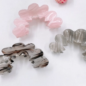 Acrylic wavy hair claws in marble patterns including pink, black-white, and grey colors