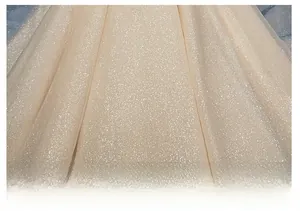Detail of champagne gold tulle wedding dress fabric with shimmering glitter powder