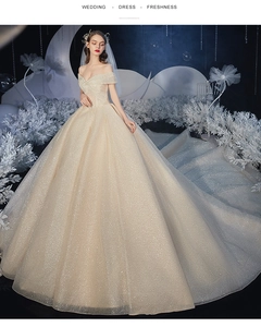 Detail of champagne sequin wedding dress featuring an off-shoulder neckline and starry glow