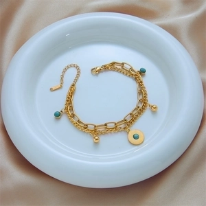 Double-layered gold stainless steel bracelet with turquoise beads and sunburst coin pendant