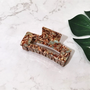 Detailed view of a large rectangular acetate claw clip with brown and blue marble pattern