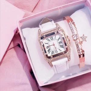 Detail of square gold diamond watch and star pendant bracelet in a pink luxury gift box