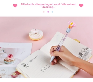 Close-up of cute light blue liquid glitter pen with pink star wing cap on pink desk