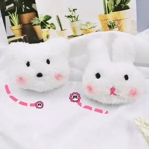 Detailed view of white plush bear and bunny brooches featuring pink blush and soft fur