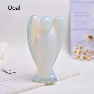 Macro shot of hand-carved opalite angel figurine with iridescent shimmer on a grid book