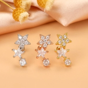 Detailed view of star-shaped zircon helix earrings in silver, rose gold, and gold finishes
