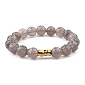 Detailed macro view of faceted grey natural stone beads with a gold copper tube accent