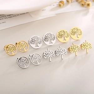 Detailed set of gold and silver tree of life earrings displayed on a rustic background