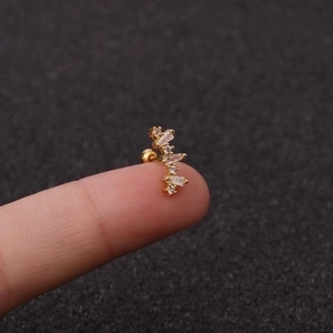 Nahaufnahme von goldenem Knorpelstecker mit Zirkonia-Stern auf einer Fingerspitze