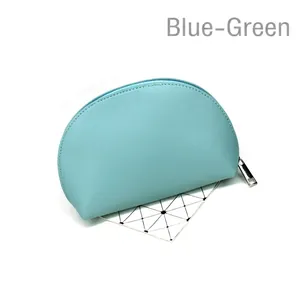 Detail of teal faux leather shell-shaped cosmetic bag with silver zipper and fine stitching