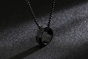 Detailed view of a black titanium steel spinning ring pendant on a matching chain