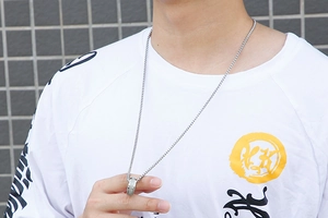 Close-up of a rotating silver titanium steel spinning necklace worn by a model