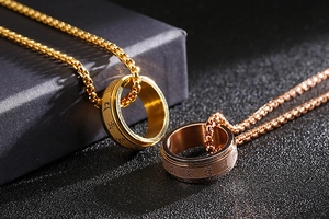 Detail of gold and rose gold stainless steel spinning rings on matching chains