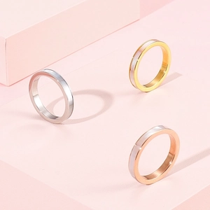 Detailed view of three-piece stainless steel Roman letter shell rings in tricolor finishes